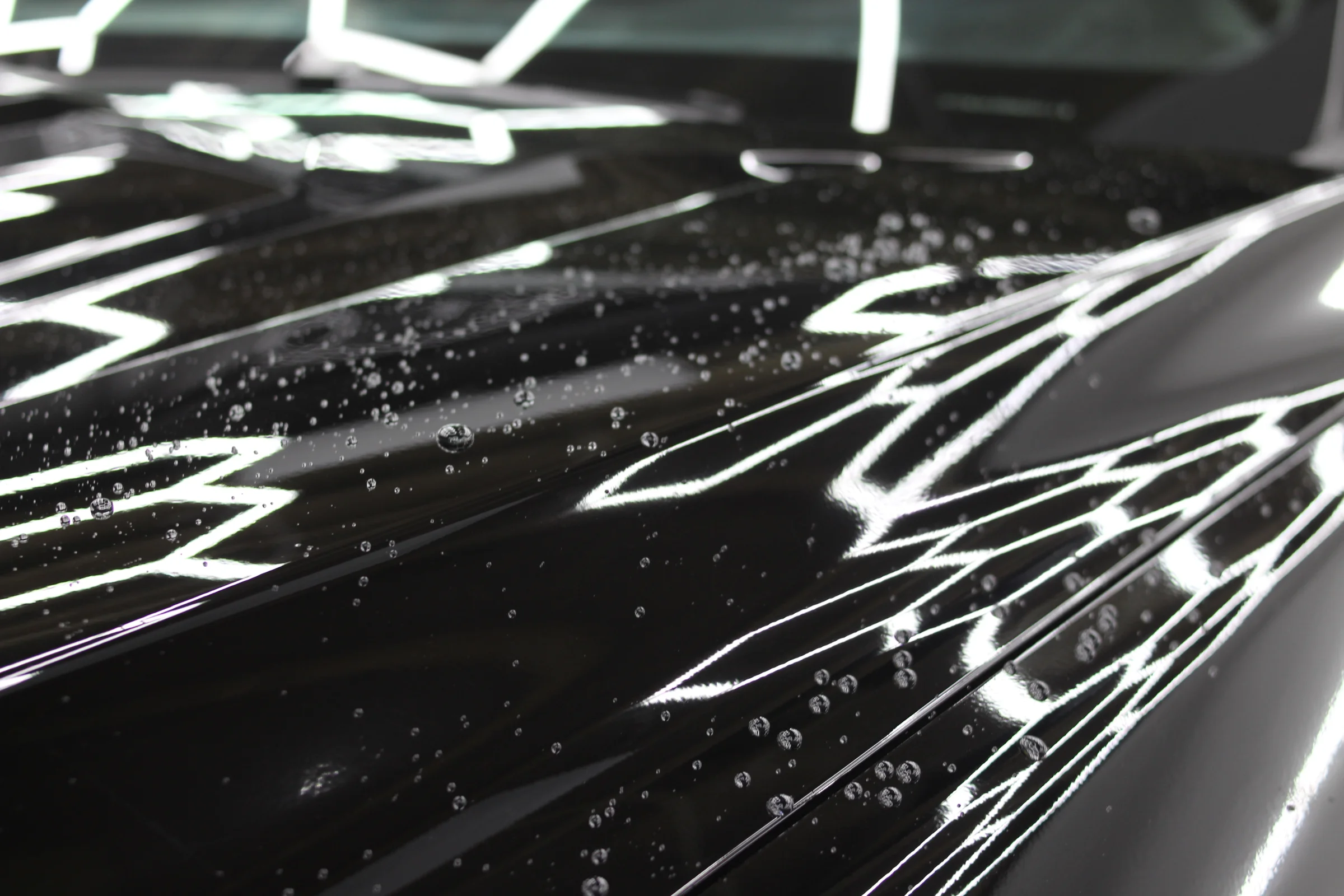 Water beading on a freshly ceramic-coated black hood